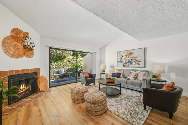 a living room with furniture a fireplace and a large window