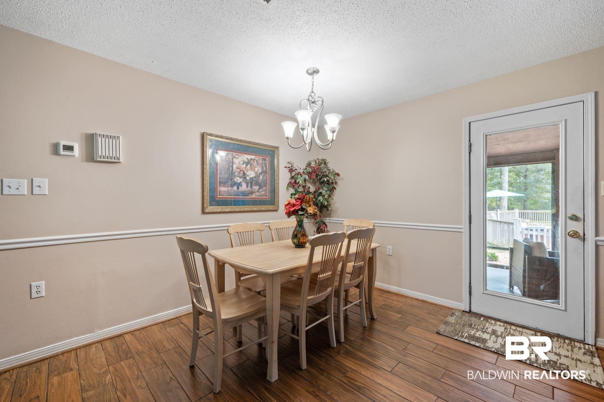 4566 McCrary Road, Unit A Semmes, AL 36575 - Photo 14 of 28 Dining space featuring dark hardwood / wood-style floors, a chandelier, and a textured ceiling