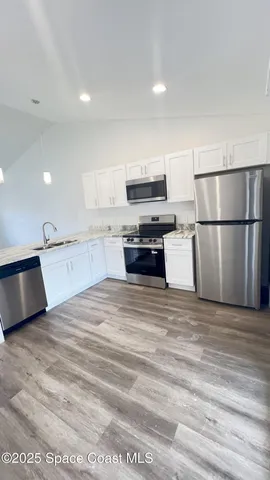 a kitchen with stainless steel appliances granite countertop a stove a refrigerator and a microwave