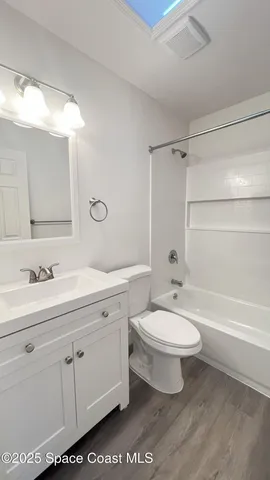 a bathroom with a double vanity sink a toilet and a bathtub