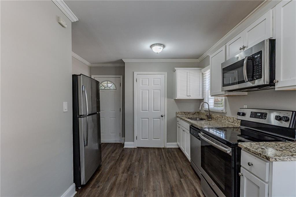 1255 Glen Forest Way Decatur, GA 30032 - Photo 4 of 23 a kitchen with stainless steel appliances granite countertop a stove a refrigerator and a microwave