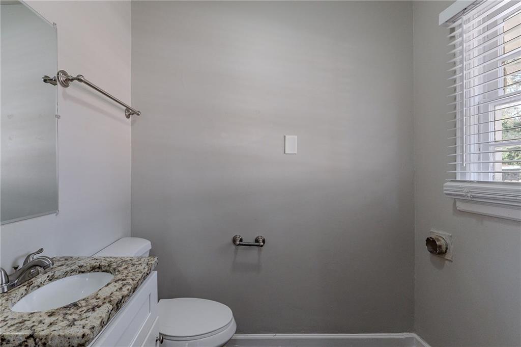 1255 Glen Forest Way Decatur, GA 30032 - Photo 9 of 23 a bathroom with a granite countertop sink a toilet and a mirror