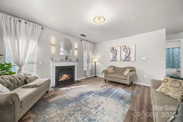 a kitchen with a refrigerator a stove top oven a sink dishwasher and white cabinets with wooden floor