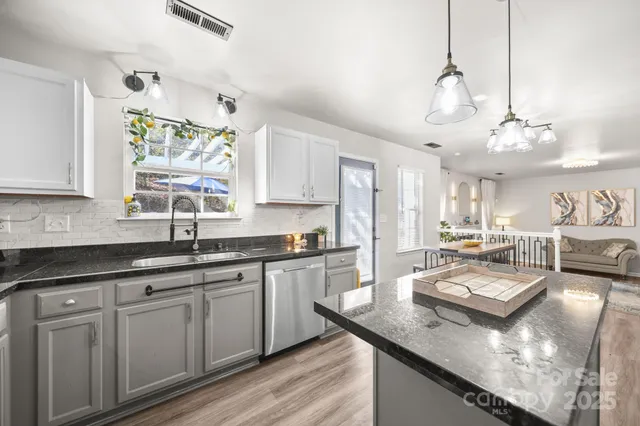 a kitchen with stainless steel appliances kitchen island granite countertop a stove refrigerator and cabinets