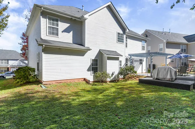 a view of a house with a chairs and table in a yard