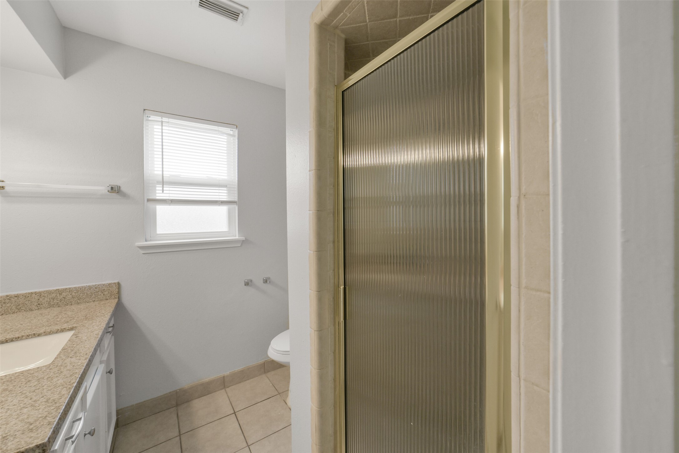 7611 Theisswood Road Spring, TX 77379 - Photo 24 of 41 a bathroom with a granite countertop sink toilet and shower
