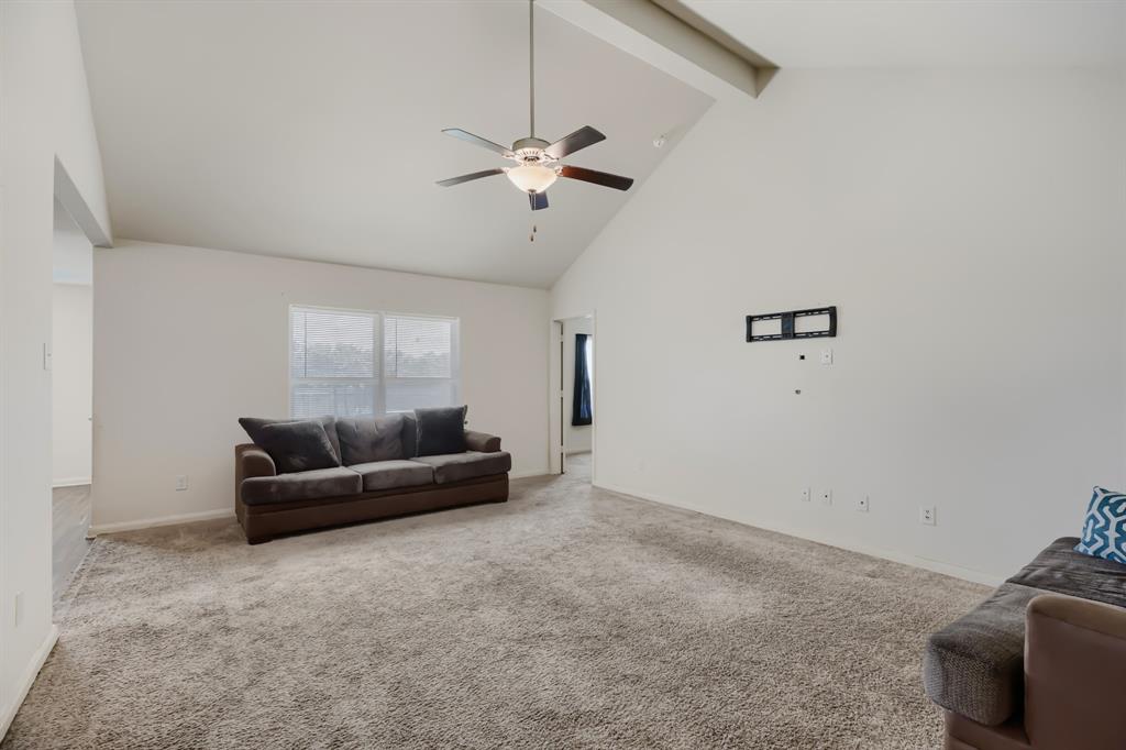 4309 Cat Tail Way Forney, TX 75126 - Photo 6 of 30 Spacious living area featuring a vaulted ceiling with exposed beam, a ceiling fan with integrated lighting, and neutral-toned carpeting