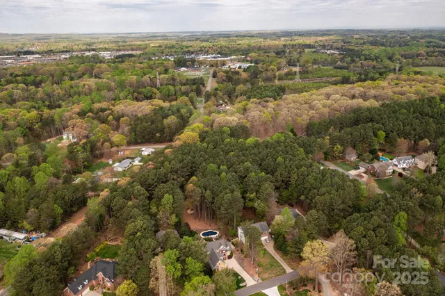 an aerial view of residential houses with outdoor space and trees
