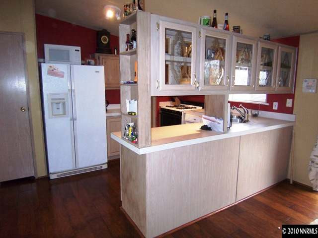175 Aries Circle Reno, NV 89521 - Photo 3 of 13 a kitchen with stainless steel appliances a refrigerator a stove and wooden floor