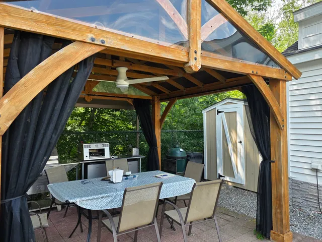 a view of patio with table and chairs under an umbrella with a small yard