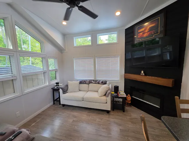 a living room with furniture a flat screen tv and a window