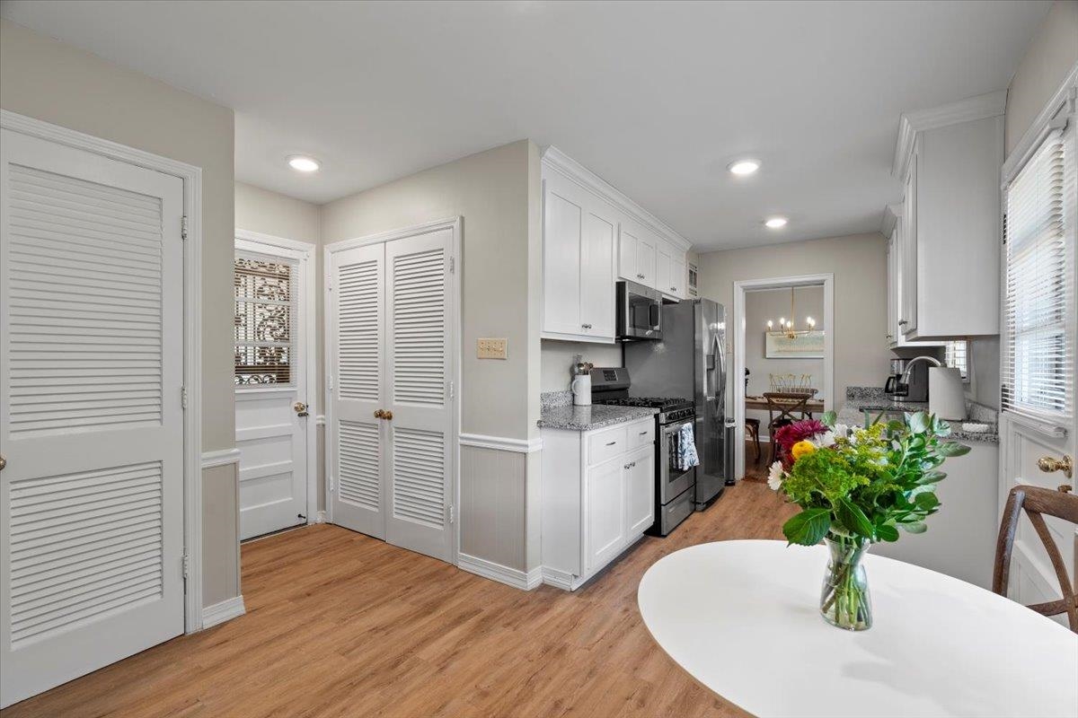 4491 Garnett Road Memphis, TN 38117 - Photo 12 of 32 Kitchen featuring white cabinetry, stainless steel appliances, recessed lighting, wood-finish flooring, and light-toned countertops