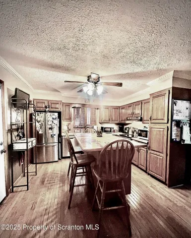 a dinning area with stainless steel appliances kitchen island granite countertop a dining table chairs and granite counter tops