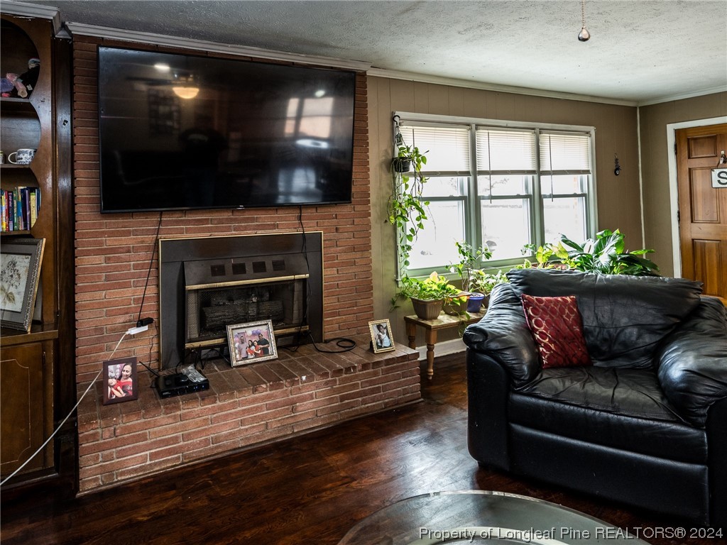 1982 Rowan Road, Unit R Lumberton, NC 28358 - Photo 25 of 43 a living room with furniture a flat screen tv and a fireplace