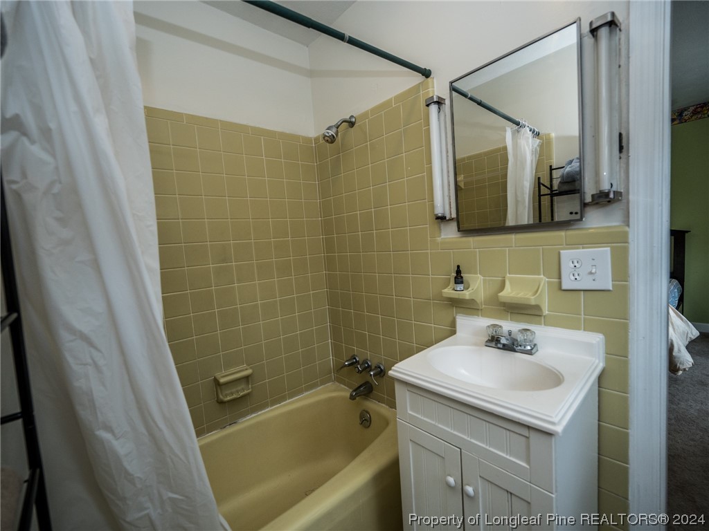1982 Rowan Road, Unit R Lumberton, NC 28358 - Photo 38 of 43 a bathroom with a sink a mirror toilet and bathtub