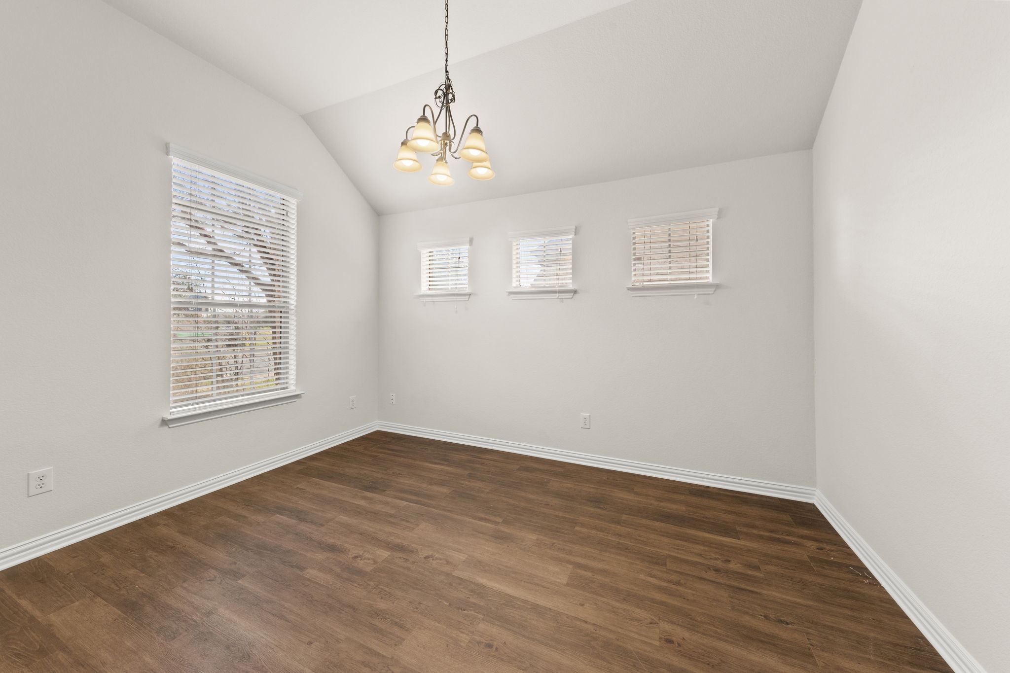 411 Tascate Street Georgetown, TX 78628 - Photo 40 of 41 Natural light illuminates rich hardwood flooring and a vaulted ceiling in this adaptable living space.
