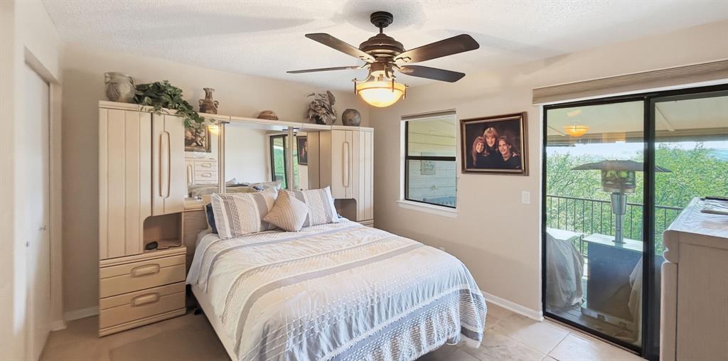 3037 Hells Gate Loop, Unit C208 Strawn, TX 76475 - Photo 16 of 24 a bedroom with a large bed and a chandelier