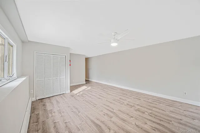 a view of an empty room with wooden floor and entryway