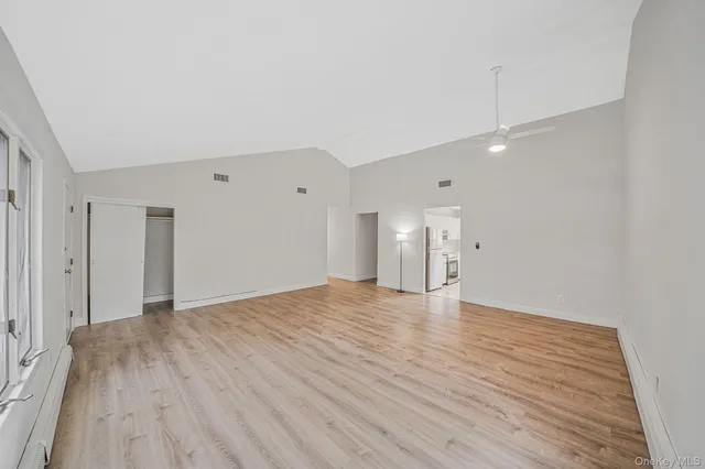 a view of an empty room with wooden floor