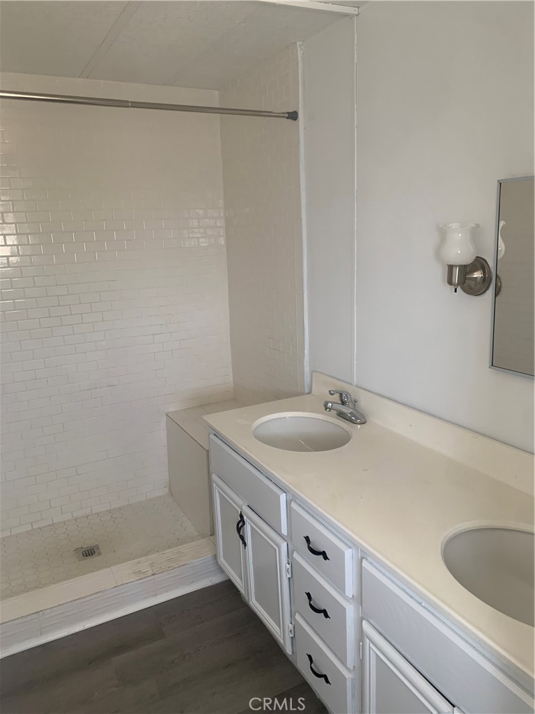 2865 West Rialto Avenue, Unit 2 Rialto, CA 92376 - Photo 11 of 19 a bathroom with a granite countertop sink and white cabinets