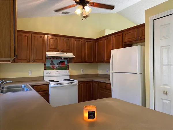 a kitchen with stainless steel appliances kitchen island a refrigerator sink and cabinets