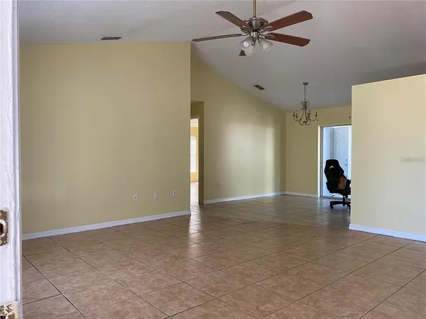 a view of a livingroom with a ceiling fan and entryway