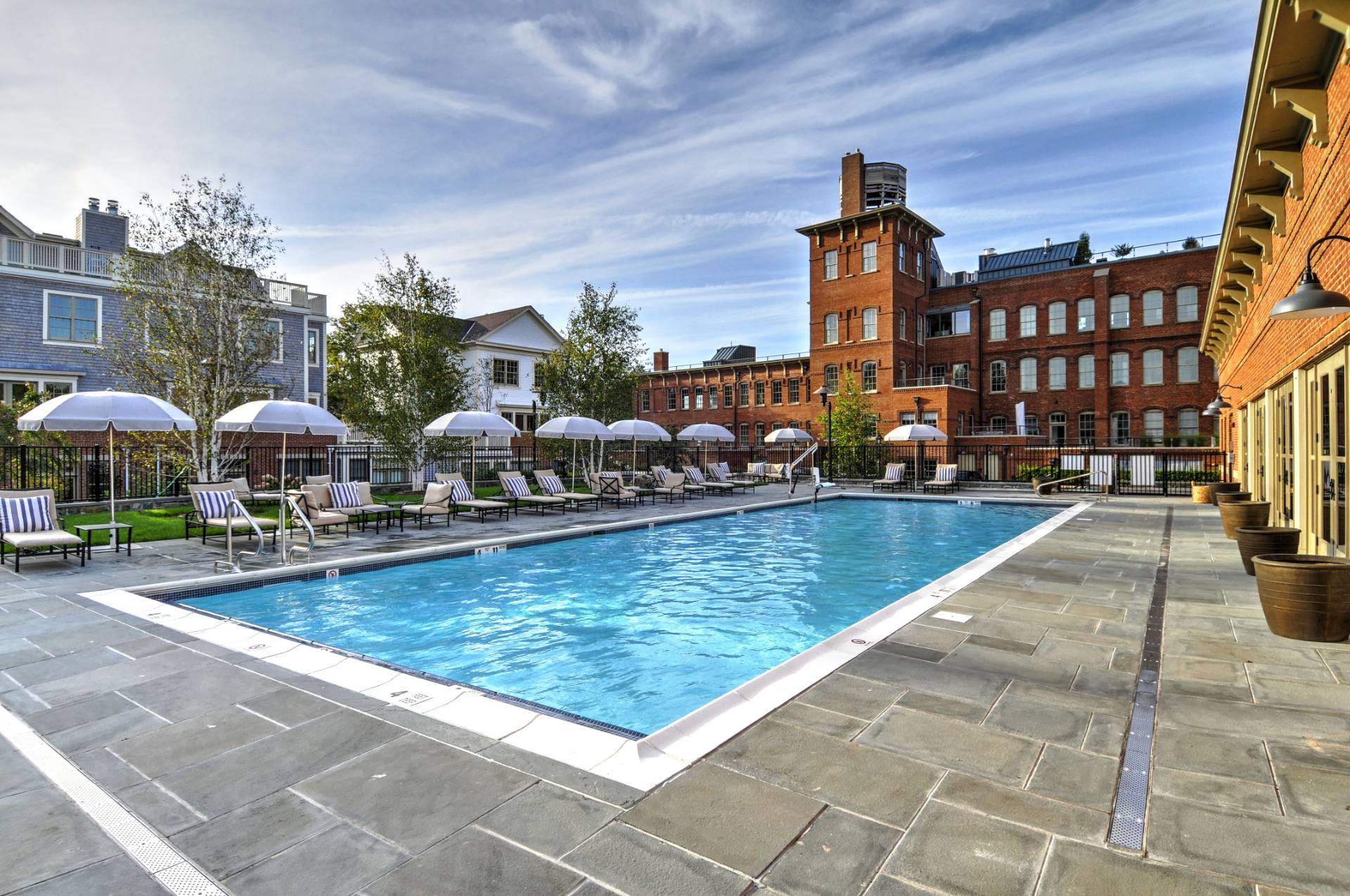 4 Sage Street Sag Harbor, NY 11963 - Photo 17 of 19 a view of a swimming pool with lawn chairs under an umbrella