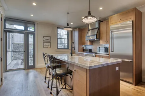 a kitchen with stainless steel appliances granite countertop a kitchen island a stove a table and chairs in it