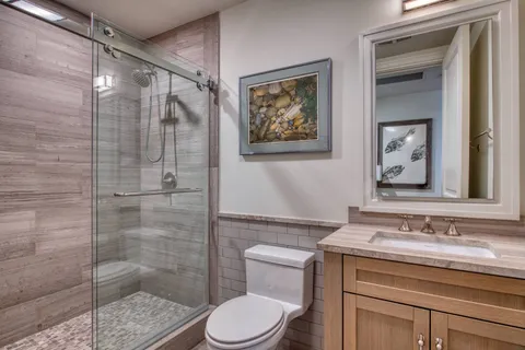 a bathroom with a granite countertop sink toilet and shower