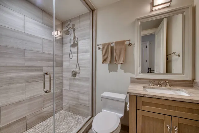 a bathroom with a sink a toilet and shower