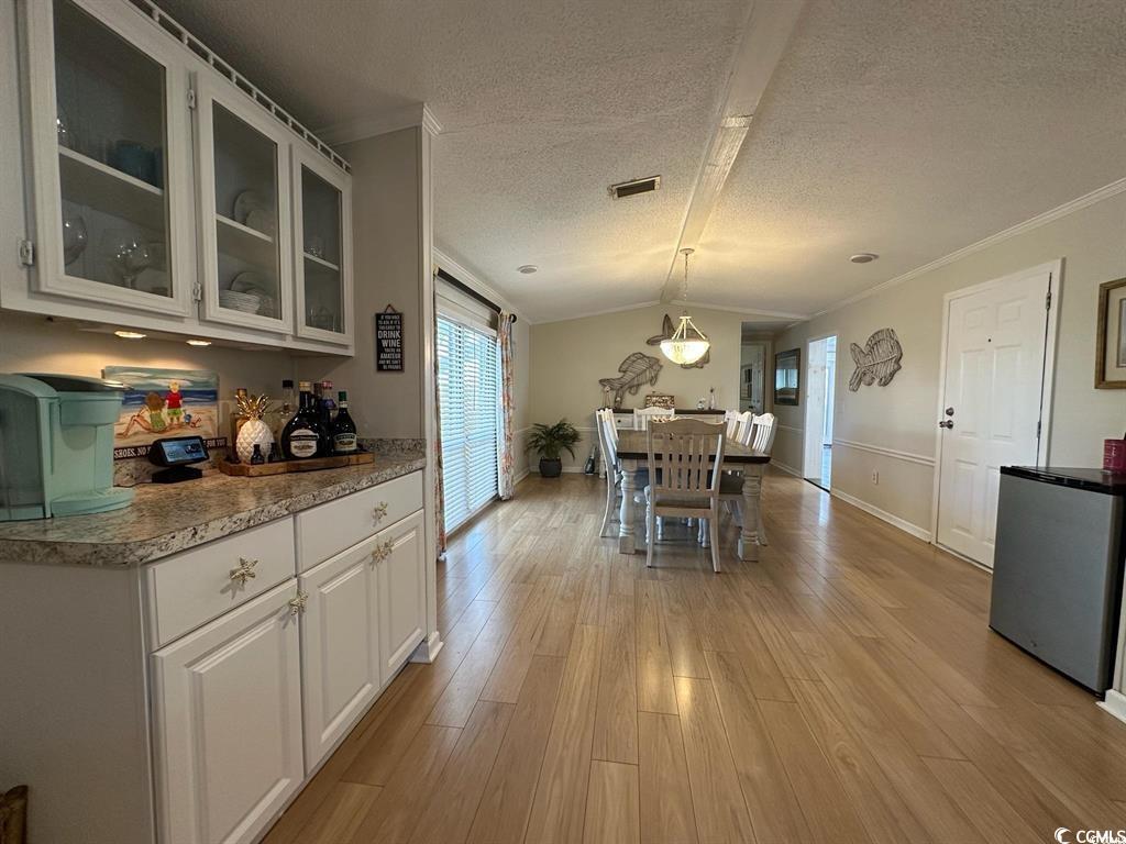 315 Inlet Road Murrells Inlet, SC 29576 - Photo 9 of 19 Dining space featuring lofted ceiling, light wood finished floors, a textured ceiling, and crown molding