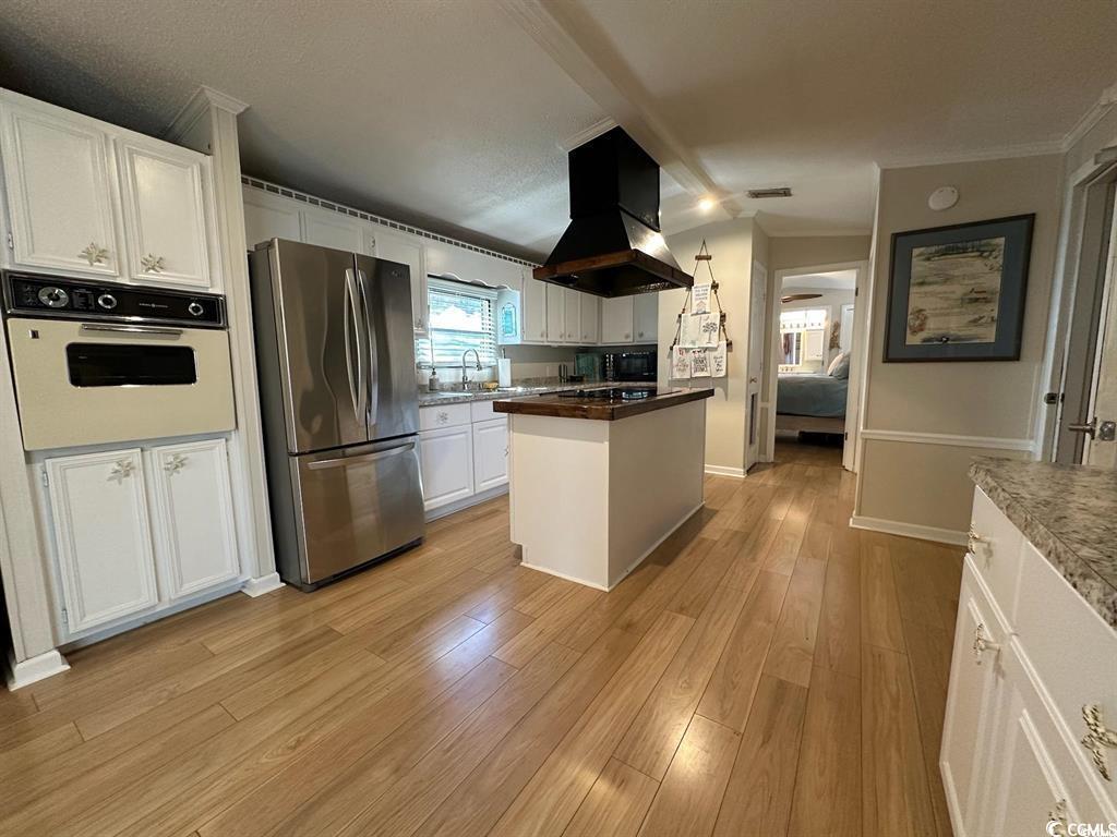 315 Inlet Road Murrells Inlet, SC 29576 - Photo 10 of 19 Kitchen with white cabinets, white oven, island range hood, freestanding refrigerator, and light wood-type flooring