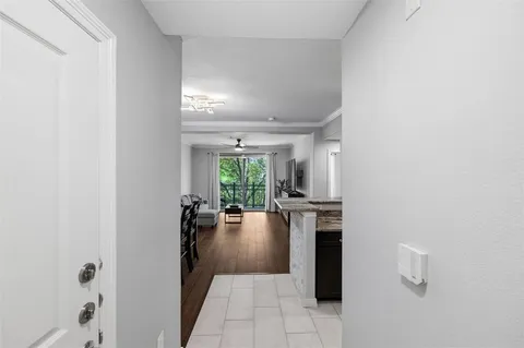 a hallway with a stove a dining table and chairs
