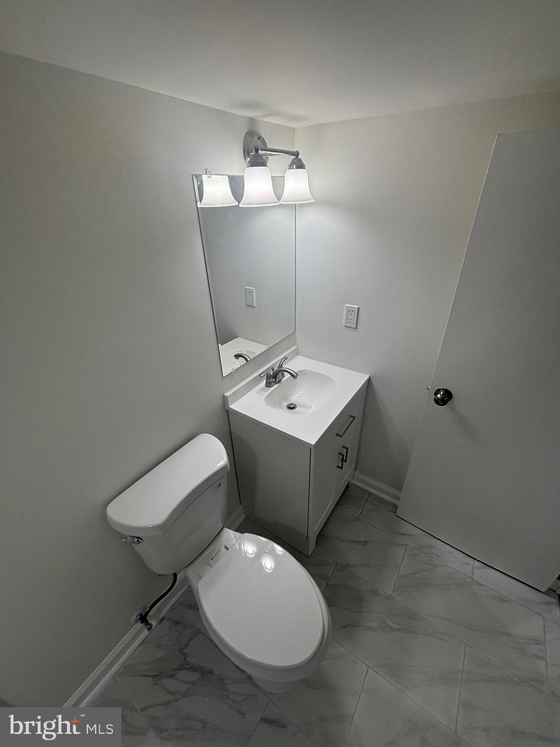 6769 Woodley Road Baltimore, MD 21222 - Photo 18 of 27 a bathroom with a toilet sink and mirror