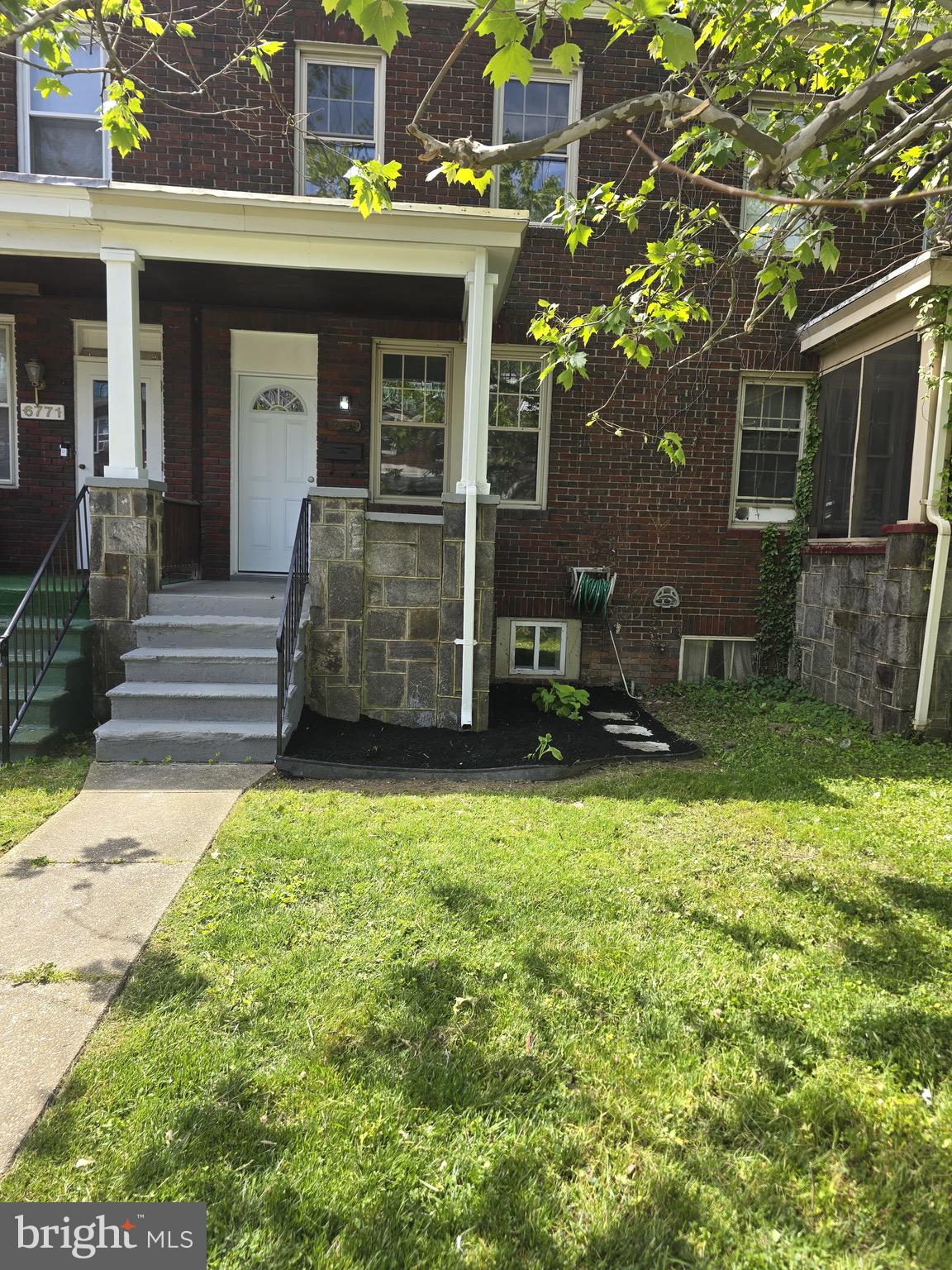 6769 Woodley Road Baltimore, MD 21222 - Photo 3 of 27 front view of a brick house with a yard