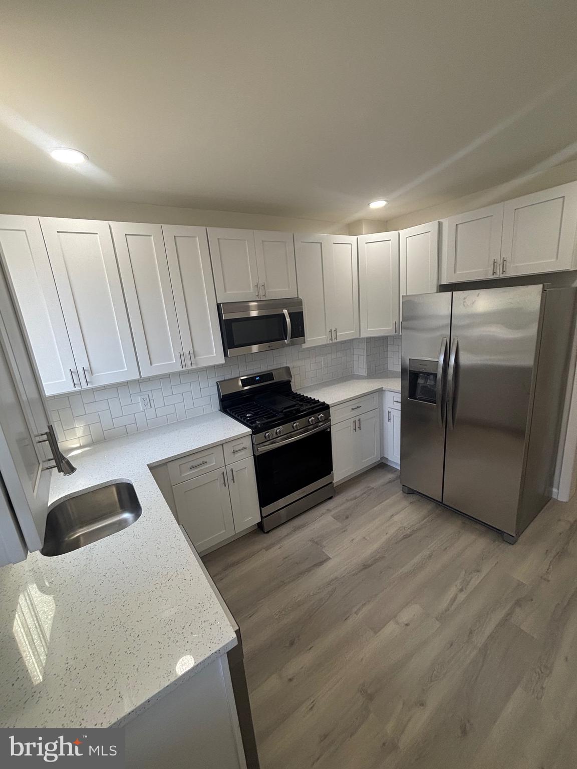 6769 Woodley Road Baltimore, MD 21222 - Photo 5 of 27 a kitchen with a refrigerator and a sink