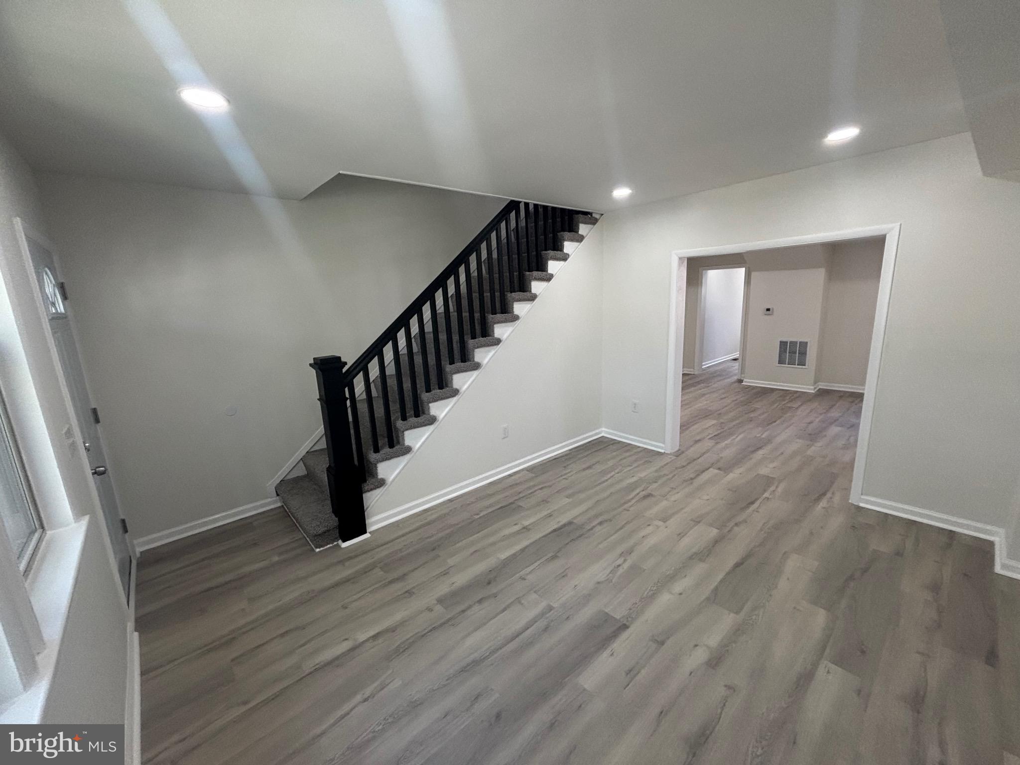 6769 Woodley Road Baltimore, MD 21222 - Photo 9 of 27 a view of an empty room with wooden floor and stairs