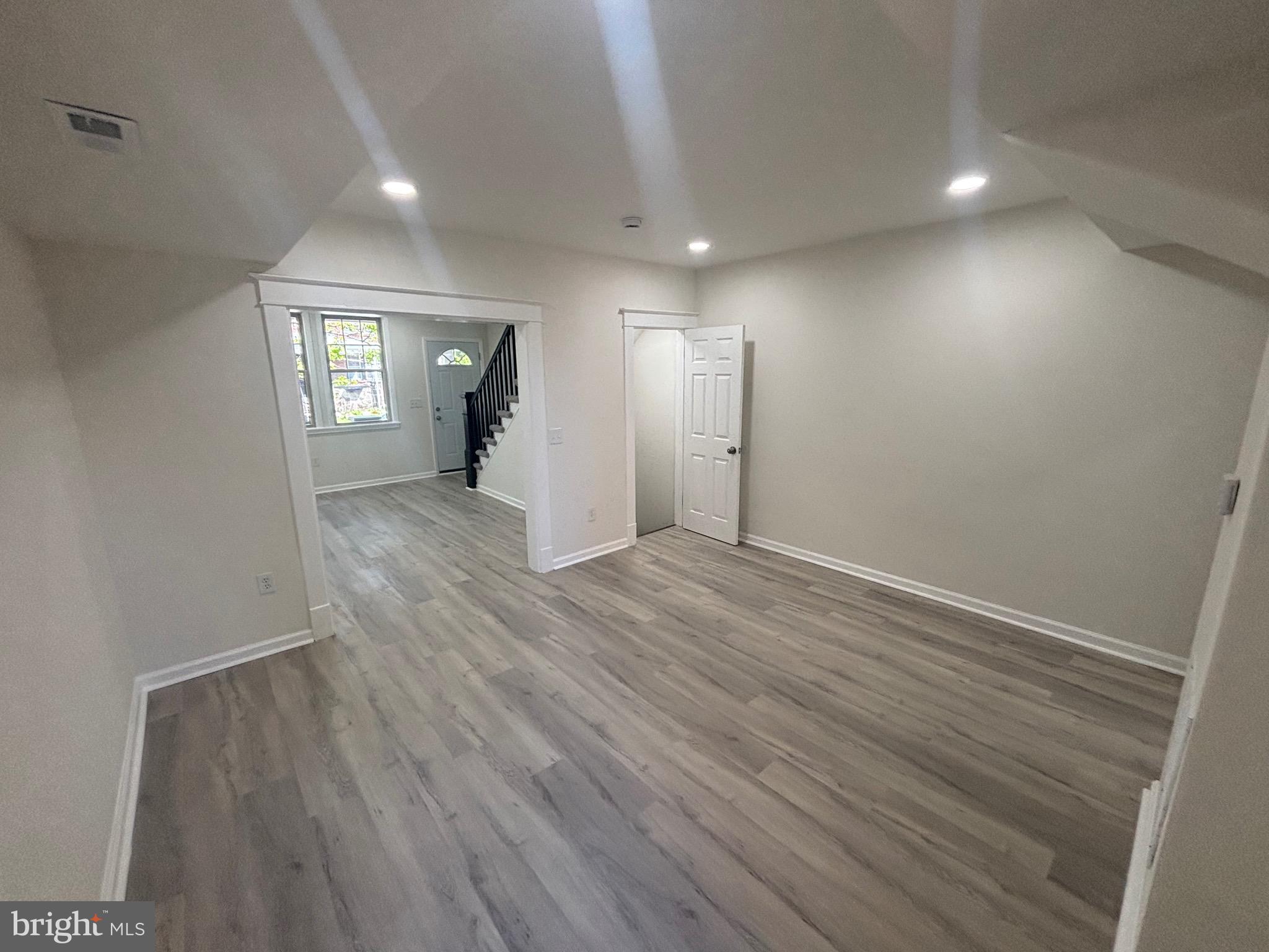 6769 Woodley Road Baltimore, MD 21222 - Photo 10 of 27 wooden floor in an empty room with a window