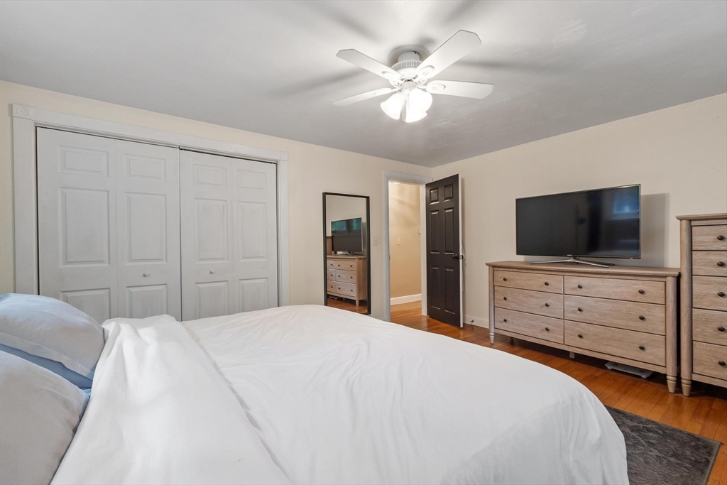 167 Gates Pond Road Berlin, MA 01503 - Photo 21 of 32 a bedroom with a large bed and flat tv screen on dresser