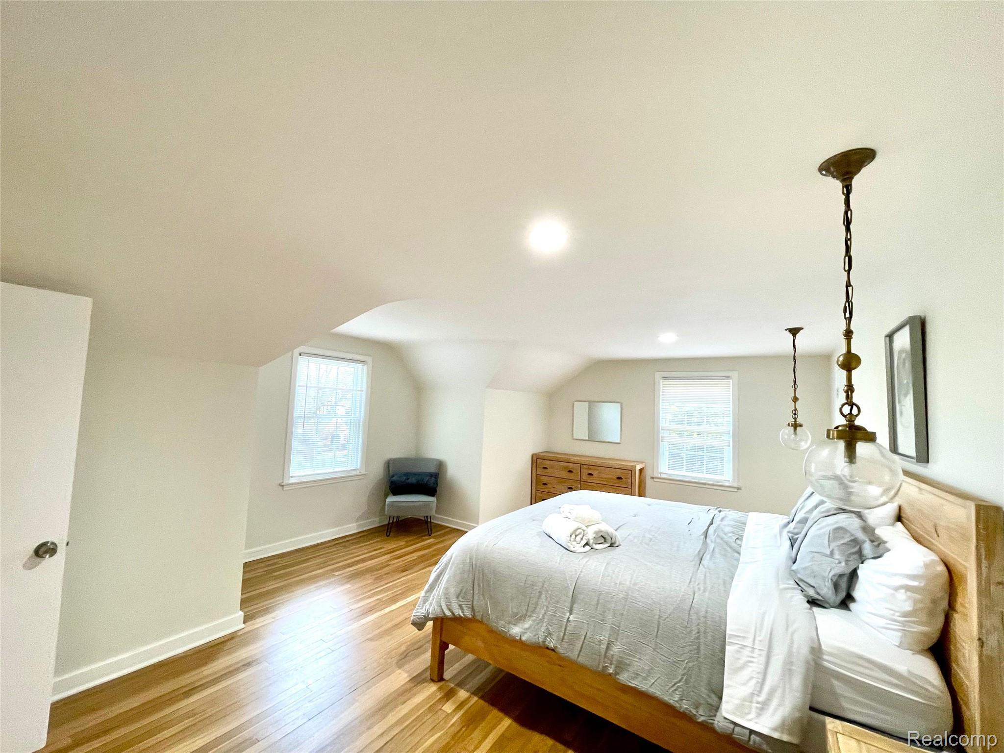 60 Devon Road Bloomfield Hills, MI 48302 - Photo 34 of 50 Bedroom featuring wood-finish flooring, two windows with blinds, recessed lighting, and sloped ceilings