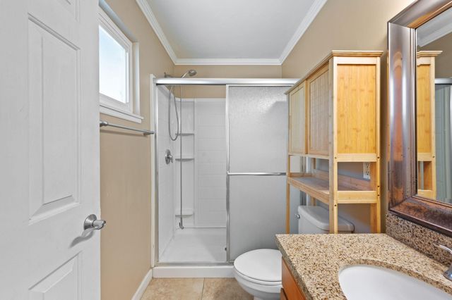 a bathroom with a granite countertop toilet a sink and a shower