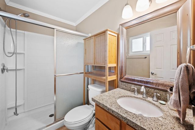a bathroom with a granite countertop sink toilet and shower