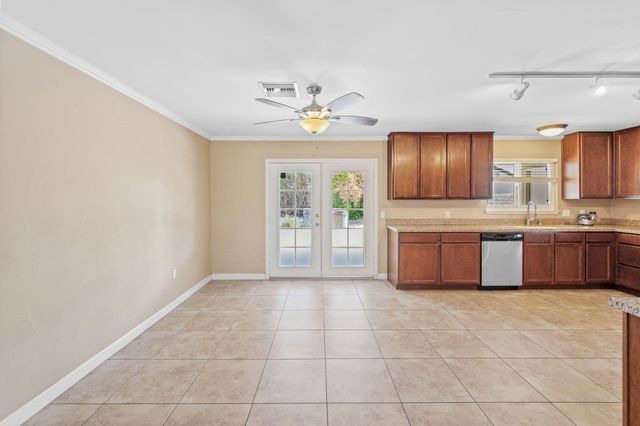 a kitchen with stainless steel appliances a sink a stove a refrigerator cabinets and a window