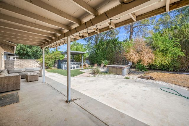 a view of a patio with a table and chairs and potted plants