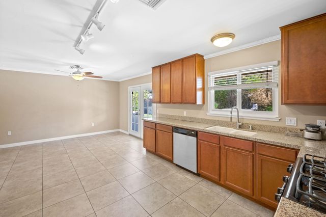 a large kitchen with kitchen island granite countertop a sink window and cabinets