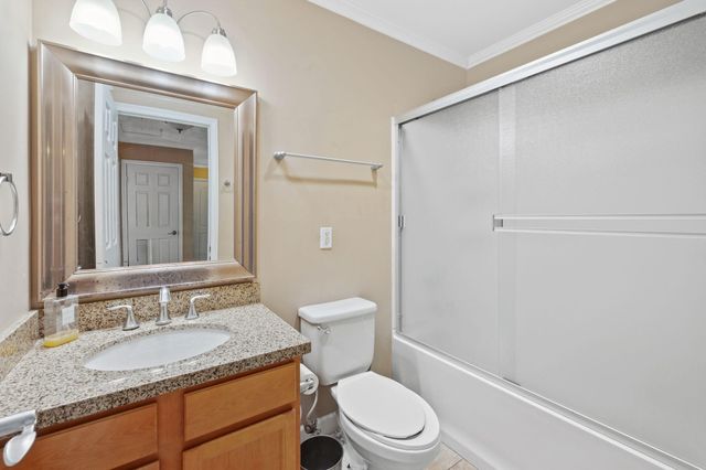 a bathroom with a granite countertop sink toilet and shower
