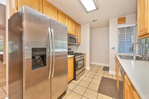 a kitchen with stainless steel appliances granite countertop a refrigerator and a sink