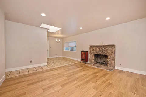 an empty room with wooden floor and fireplace