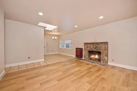 a view of empty room with wooden floor and fireplace