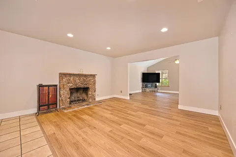 a view of empty room with wooden floor and fireplace